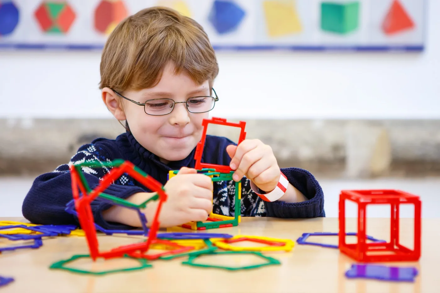 Children sorting geometric shapes together on the floor